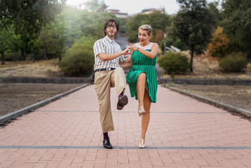 Swing dancers having fun outdoors in the park. Lifestyle concept about people dancing swing music Lindy hop together and having fun!