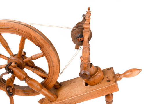 Old wooden yarn spinning wheel isolated on a white background. Very old wheel and spokes of a hand crafted spinning wheel made from natural wood. Historical working tool. Isolated on white background.