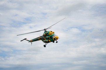 Fototapeta na wymiar Khaki colored helicopter is flying in blue sky