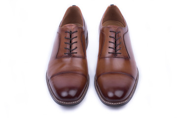 Clean, classic leather elegant shoe on a white background. Beautiful brown luxury and casual leather men shoes. Fashion accessory. Top, front view.Both legs on the ground. Isolated. 