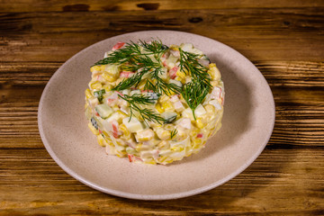 Salad with crab sticks, boiled eggs and cucumbers on a ceramic plate