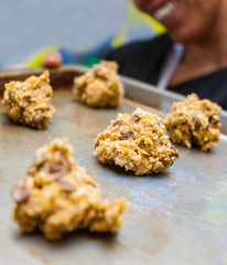 Close Up of Chocolate Chip Cookie Dough Balls on a Tray Held by a Smiling Woman