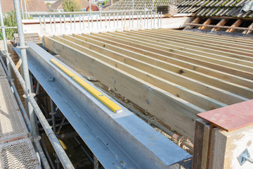 Renovation projects. Building of extension of the existing house, unfinished wooden roof structure, steel beams,brick walls. steel beams, selective focus