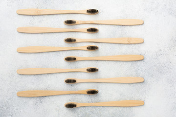 Zero waste eco friendly bamboo toothbrushes on white table, top view, selective focus