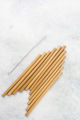 Stack of eco friendly biodegradable bamboo straws on white table, selective focus