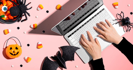 Halloween decorations with person using a laptop computer - overhead view flat lay
