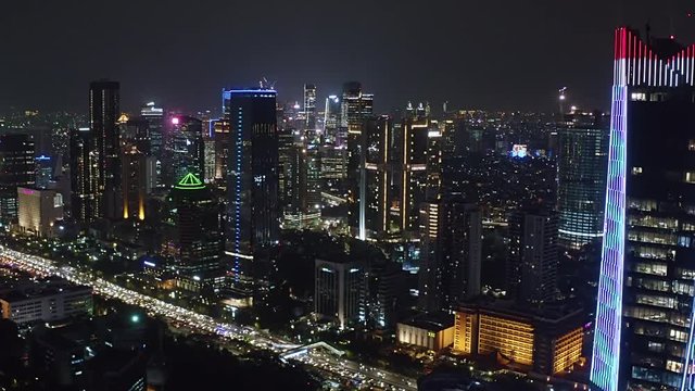 JAKARTA, Indonesia - October 07, 2019: Beautiful aerial view of central business district with night lights and skyscrapers. Shot in 4k resolution from a drone flying forwards