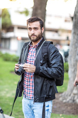 Photographer with beard and photographic camera outdoor.