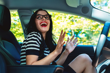 Woman in a self-driving autonomous electric vehicle with hands off the steering wheel