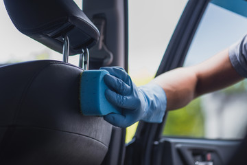 partial view of car cleaner wiping car seat with sponge