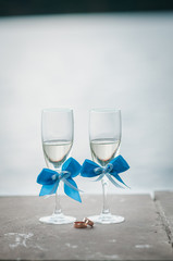 Glasses of champagne and gold wedding rings lies on the tile