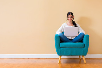 Young woman with a laptop computer sitting in a chair