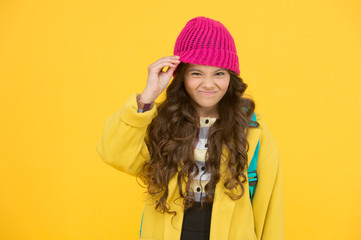 Hat really bothers me. Small kid dislike wearing hat. Little kid take off hat on yellow background. Cute kid in formal autumn style. Small kid with beauty look go to school