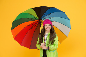 Umbrella cant stop rain. Happy small child in raincoat carry umbrella against rain. Cute little...