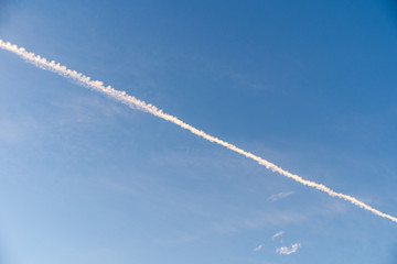 Sky morning evening with central diagonal contrail horizontal cirrus cirrocumulus clouds