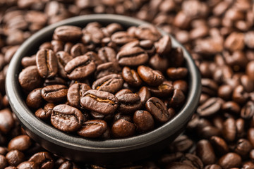 Roasted coffee beans in a black bowl