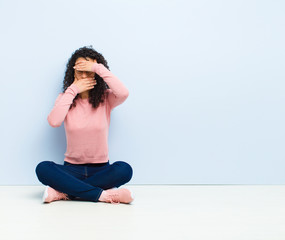 young pretty woman covering face with both hands saying no to the camera! refusing pictures or...