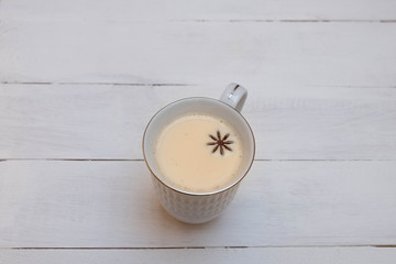 Indian milk tea masala in white ceramic mug on white wooden  background