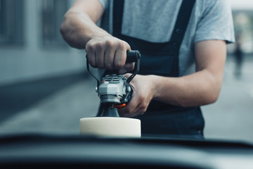 cropped view of car cleaner polishing car with buffer machine