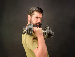 Fototapeta na wymiar Handsome athlete man holds dumbbell. Strong man training with dumbbells. Fitness. Bearded man exercise with dumbbell. Muscular sportsman with dumbbells training at gym. Sportsman making weightlifting.