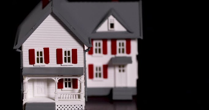 Slow Panning of Miniature Model House on Dark Wood Surface.