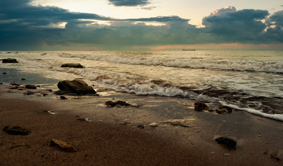 Fototapeta na wymiar Sandy beach with stones in the morning