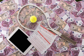 top view of digital tablet, betting lists, tennis racket and ball on euro and dollar banknotes, sports betting concept