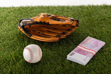 baseball glove and ball near euro banknotes on green grass isolated on white, sports betting concept