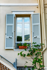 Beautiful window with shutters and flowers. Vertical.