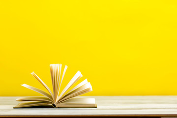 Open book, hardback books on wooden table. Back to school. Copy space.