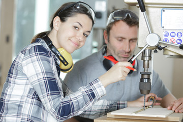 engineer training female apprentice on milling machine