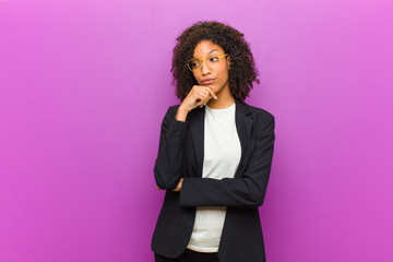 young black business woman thinking, feeling doubtful and confused, with different options,...