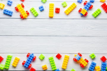 Colorful kids toys frame on wooden background. Top view. Flat lay. Copy space for text.