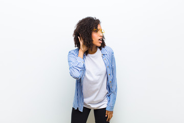 young cool african american woman looking serious and curious, listening, trying to hear a secret...