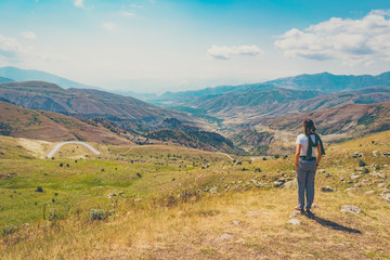 Fototapeta premium happy tourist girl visiting Monastery of Armenia. Travelling around caucasus and watching landscape of Armenian mountains