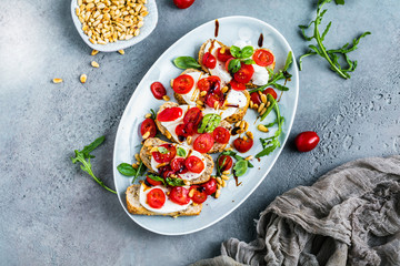 Italian bruschetta with chopped tomatoes, basil and mozzarella on grilled crusty bread