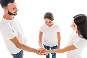 Obraz premium overhead view of smiling family putting hands together isolated on white