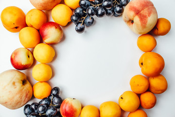 Fruit peaches, apricots and grapes on a white background