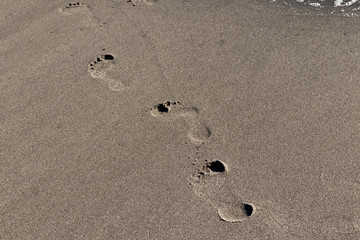 Fototapeta na wymiar Footprints on the sea shore sand