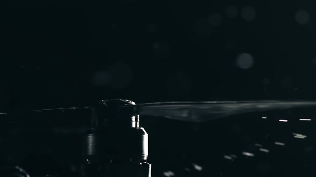 Wet drone rotor begins rotation. UAV take off at rainy night. Slow motion shot on Red camera
