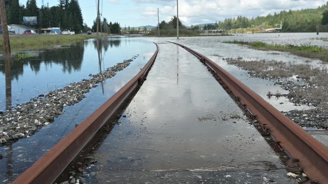 Zoom out of flooded railroad tracks due to global warming