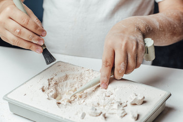 Archaeological excavations. hands closeup on a white background. Mammoth skeleton