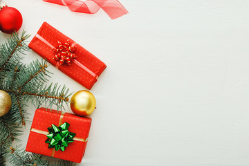 Xmas New Year 2020 holiday celebration pattern composition made of red present gift boxes, fir branches, balls on white wooden background.Concept Christmas time, winter. Flat lay, top view, copy space