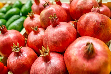 Fresh fruit stall concept, pile of pomegranate in the black box basket from farmer for sale, red fruit for texture background around the market