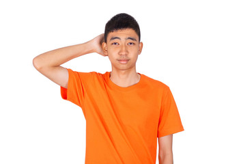An Asian boy in orange shirt is scratching his head.