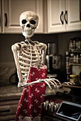 Halloween skeleton in the kitchen getting ready to prepare food for the holiday