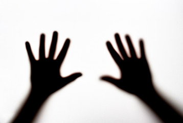 Dark silhouette of female hands on white background, concept of fear
