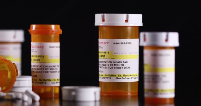 Slow Panning of Non-proprietary Medicine Bottles and Pills on Dark Wood Surface