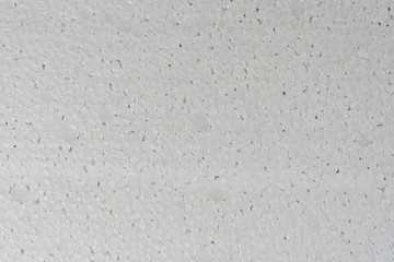 White abstract polystyrene foam background texture close-up detail view. Polystyrene, styrofoam, plastic sheet abstract synthetic packaging material.