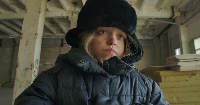 Sick homeless Caucasian girl with grey eyes caughing and looking away. Sad hopeless child living on the streets.
